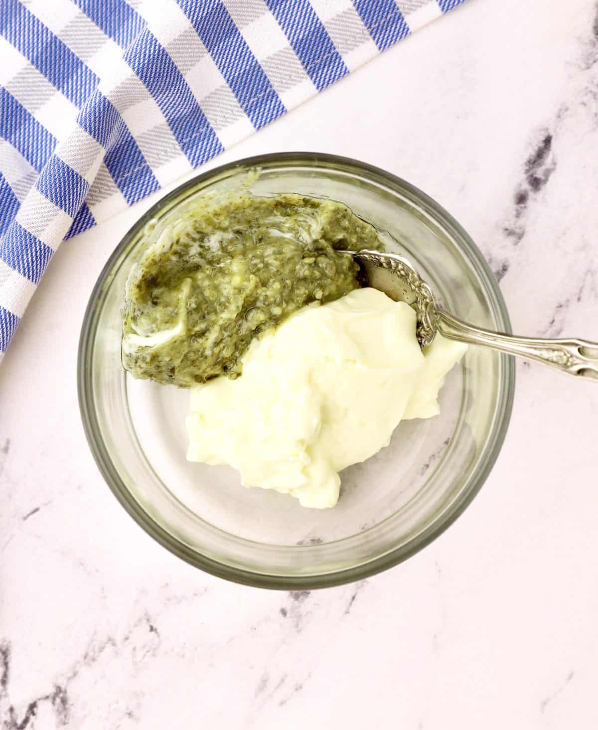 Basil pesto and mayonnaise in a small glass dish. 