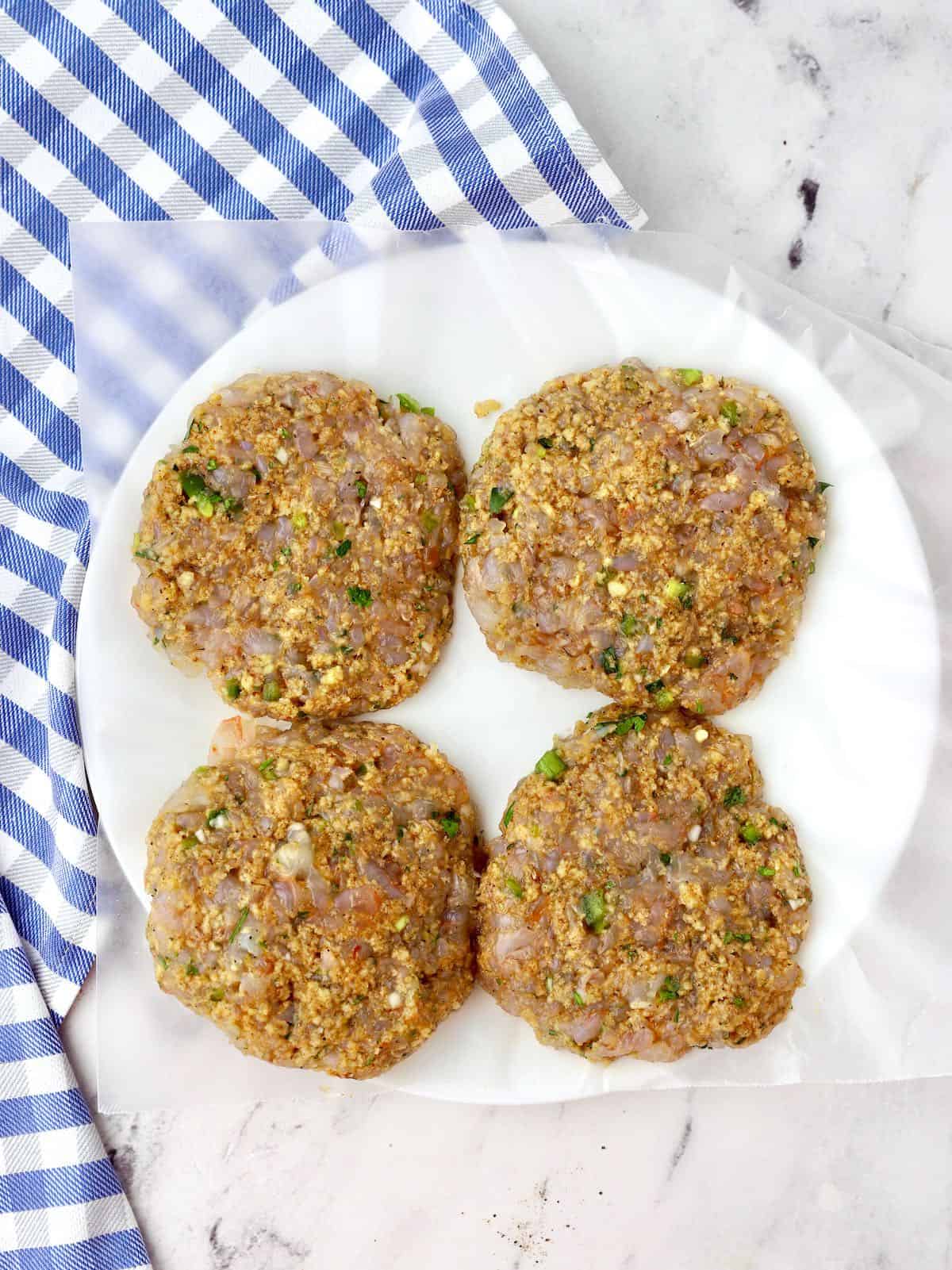 Four shrimp patties on a plate. 