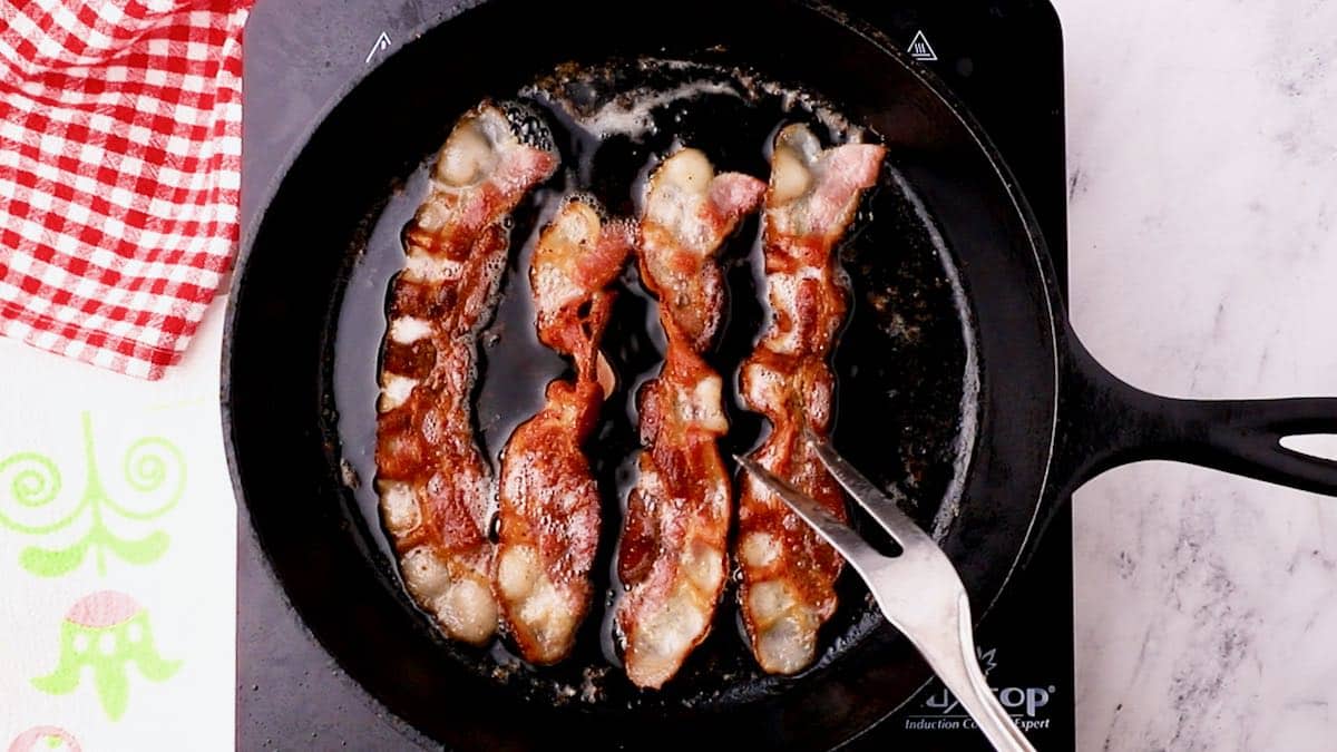 Frying bacon in a cast-iron-skillet. 