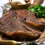 Two smoked ribeye steaks on a cutting board.