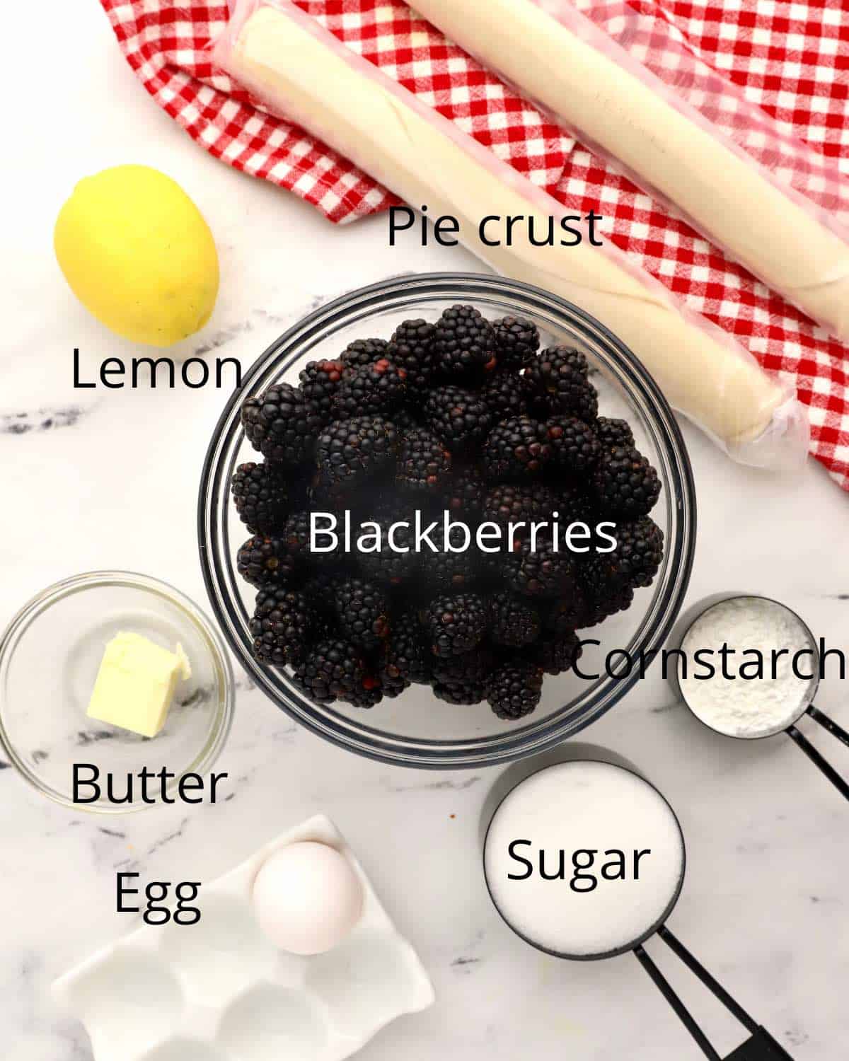 A bowl of blackberries and other ingredients for a blackberry pie. 