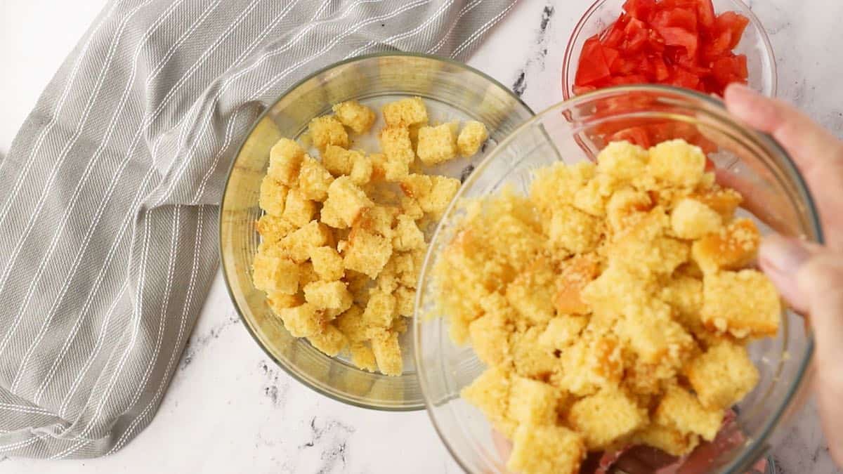 Adding cubes of cornbread to a trifle dish.  
