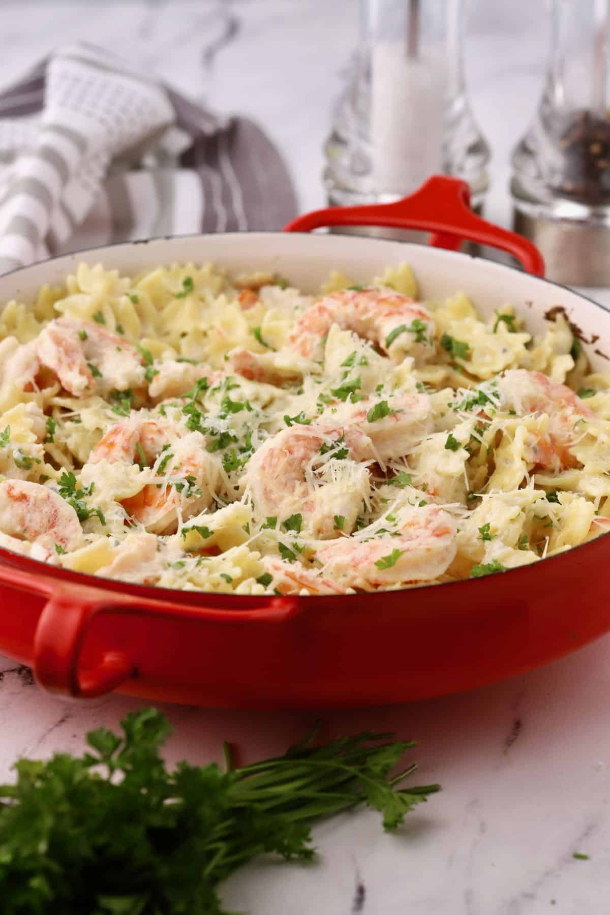 A baking dish full of shrimp pasta with blue cheese. 