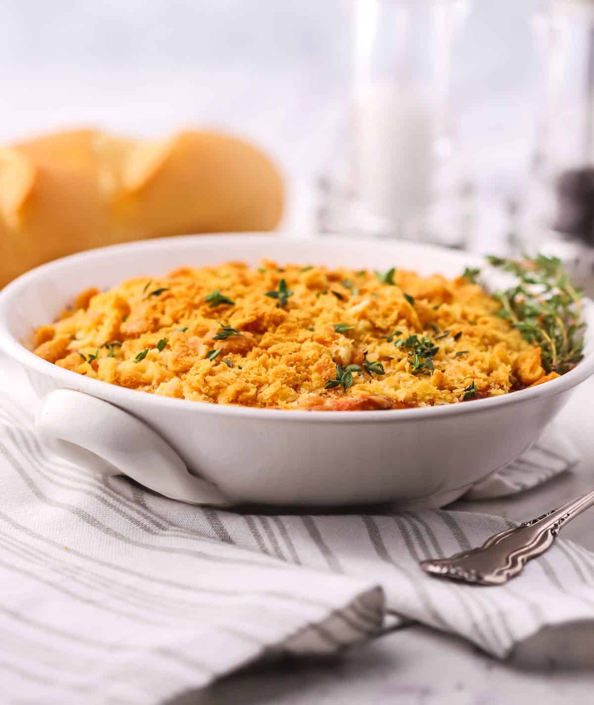 Onion casserole topped with Ritz cracker crumbs in a white dish. 