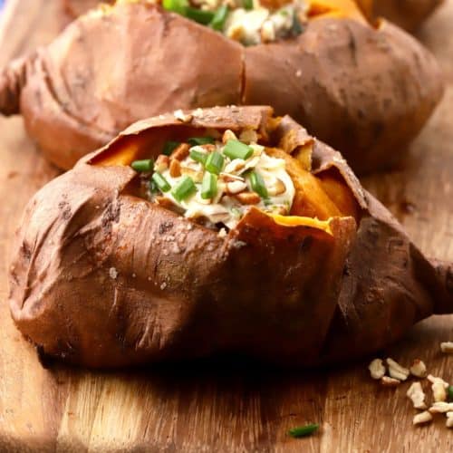 Smoked sweet potato topped with butter with pecans and chives.