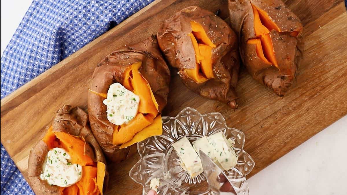 Cooked sweet potatoes sliced and open ready for butter. 