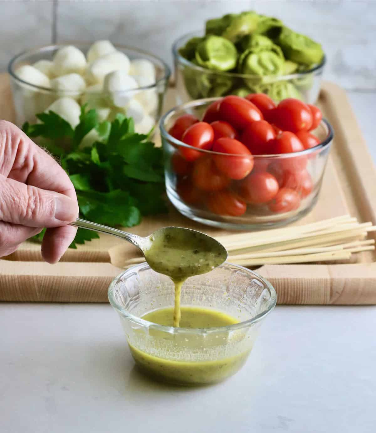 Making caprese salad dressing in a small bowl. 
