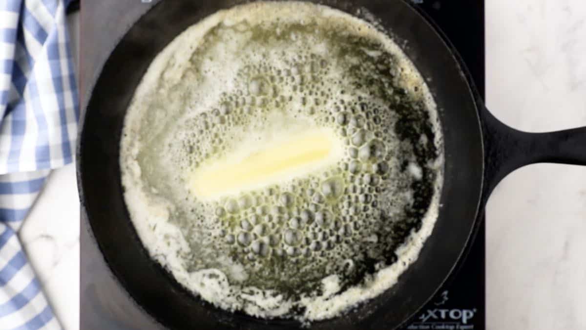 A stick of butter melting in a skillet. 