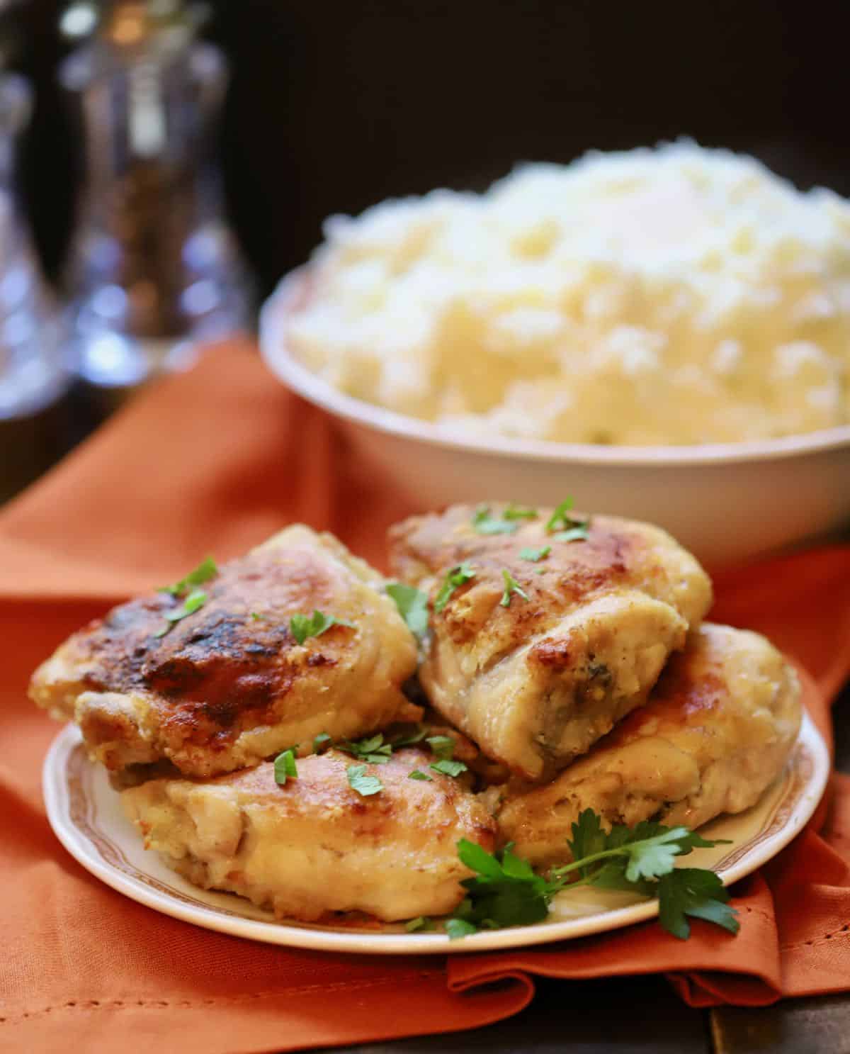 Four oven-fried chicken thighs on a plate. 
