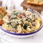 Zucchini Mushroom Pasta in a white bowl topped with parsley.
