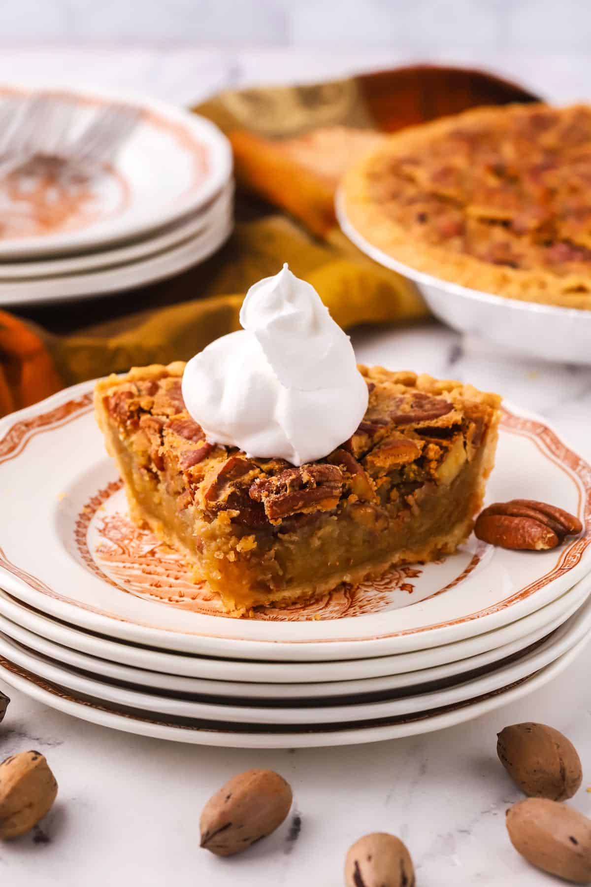 A slice of pecan pie topped with whipped cream.