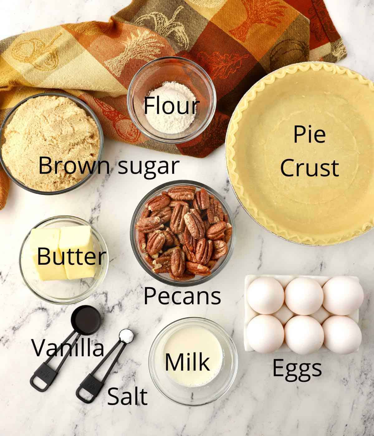 Ingredients for a pecan pie including a pie crust and pecans. 