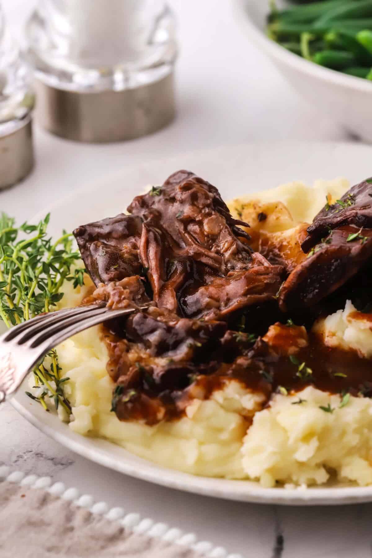 Beef short ribs on a bed of mashed potatoes. 