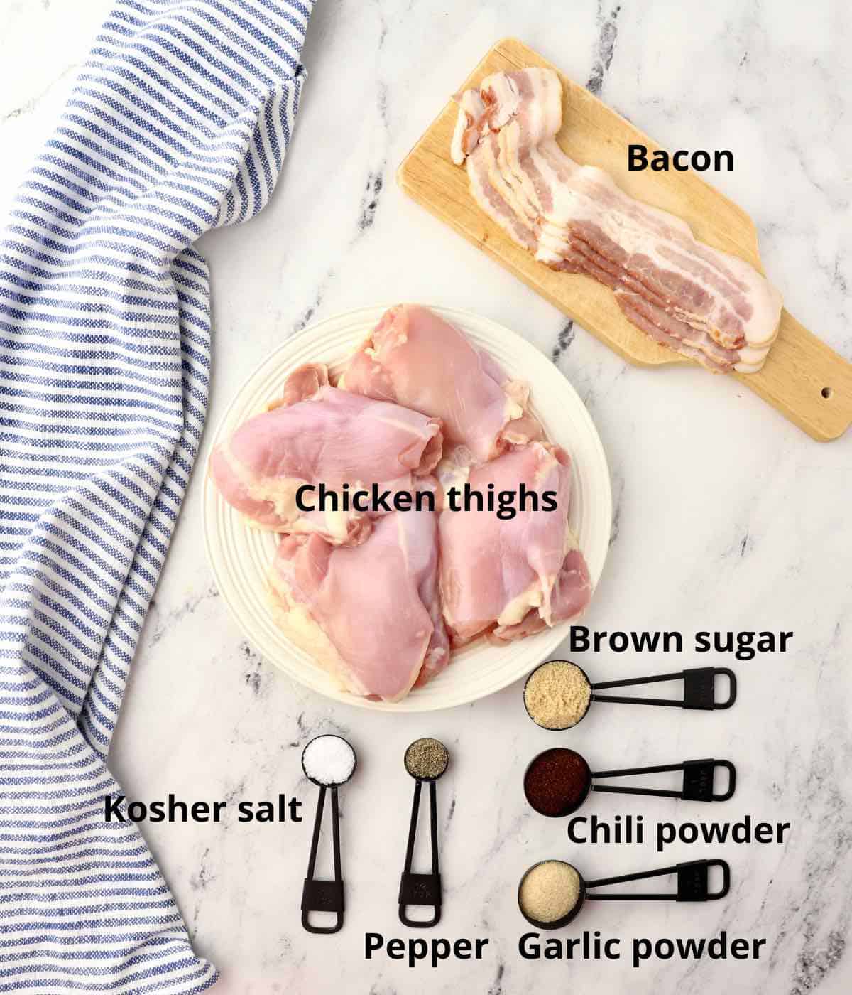 A plate of chicken thighs plus ingredients for a rub.