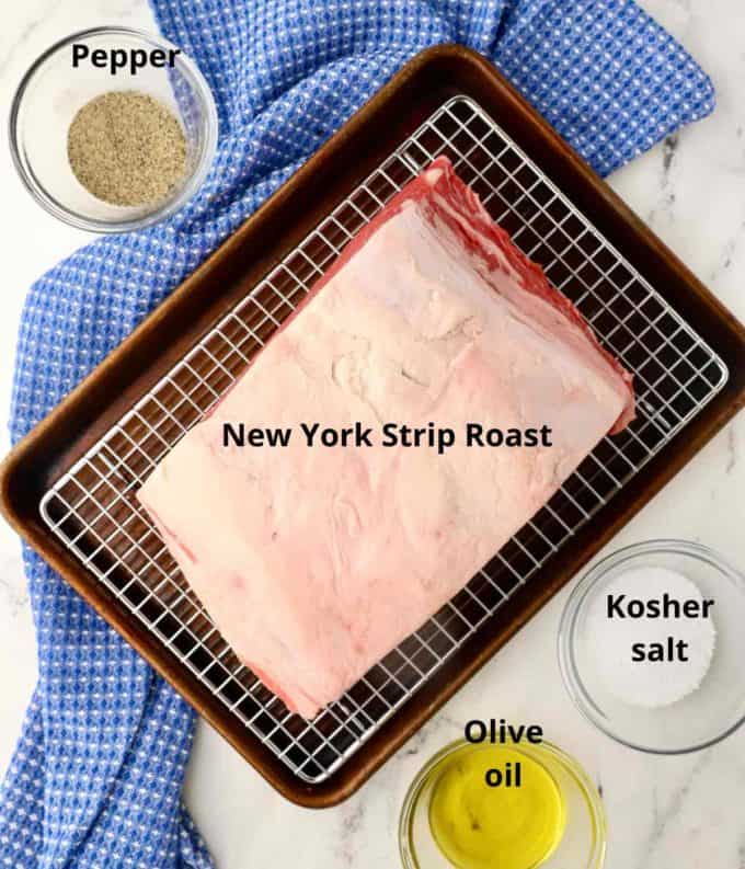 A New York Strip Roast with seasonings on a wire rack. 