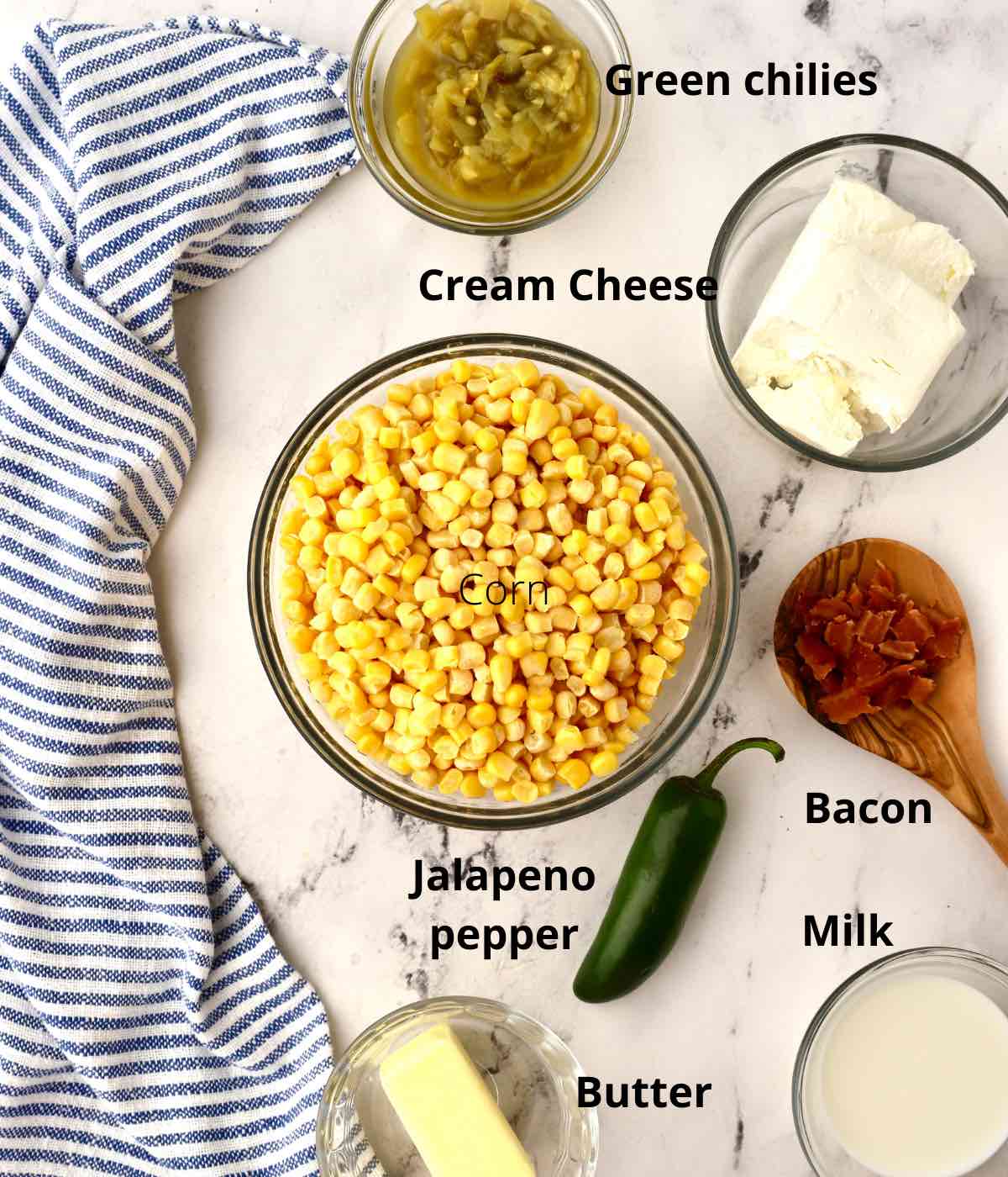 Ingredients for a corn casserole including corn, cream cheese and bacon. 