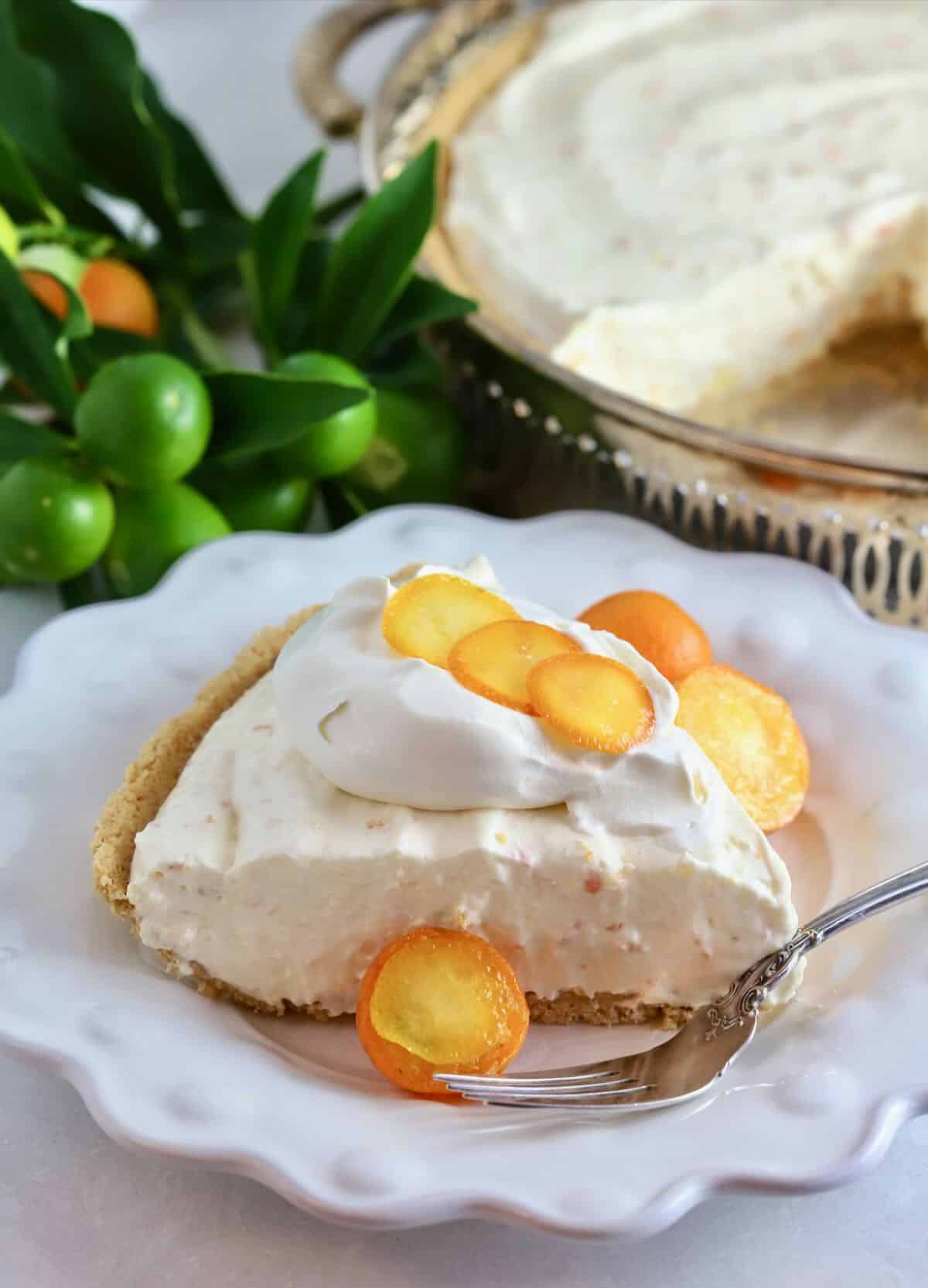 A slice of kumquat pie garnished with with candied kumquat slices.