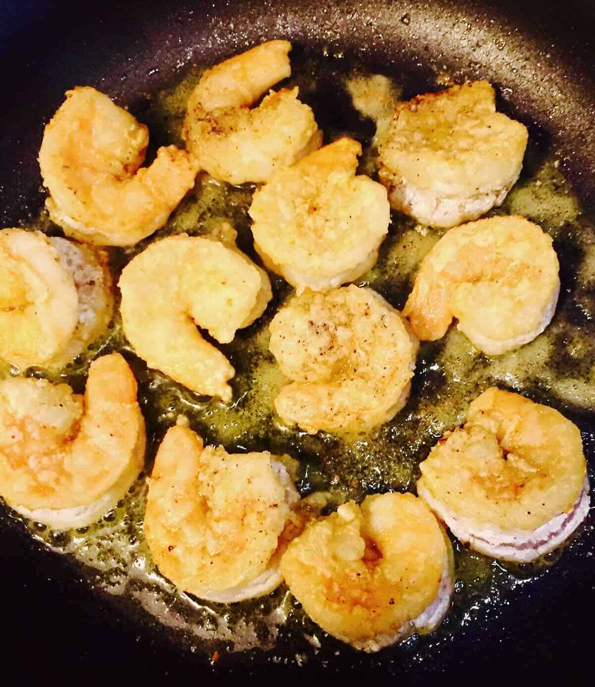 Shrimp pan-frying in a skillet. 