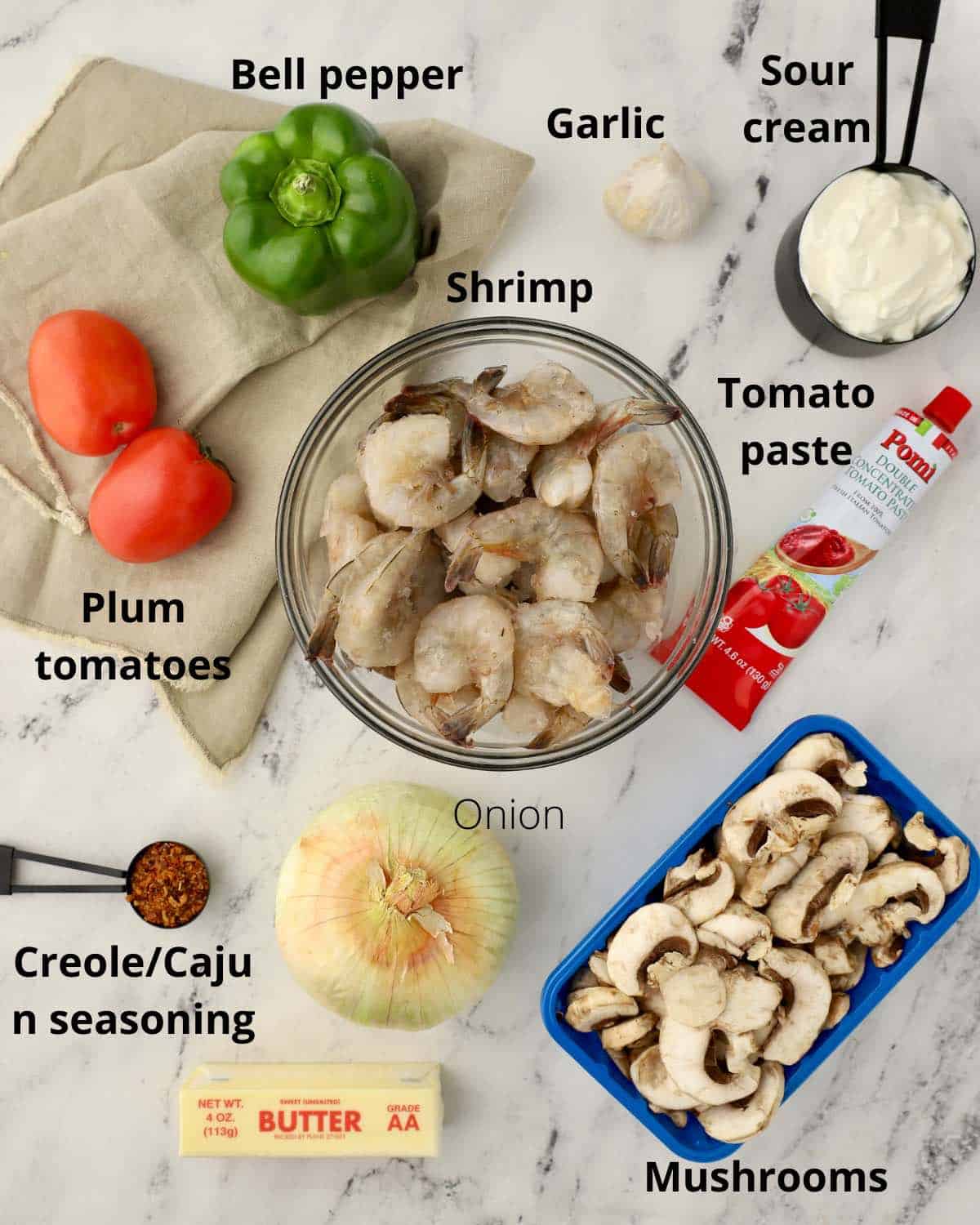 A bowl of raw shrimp with other ingredients to make shrimp creole. 