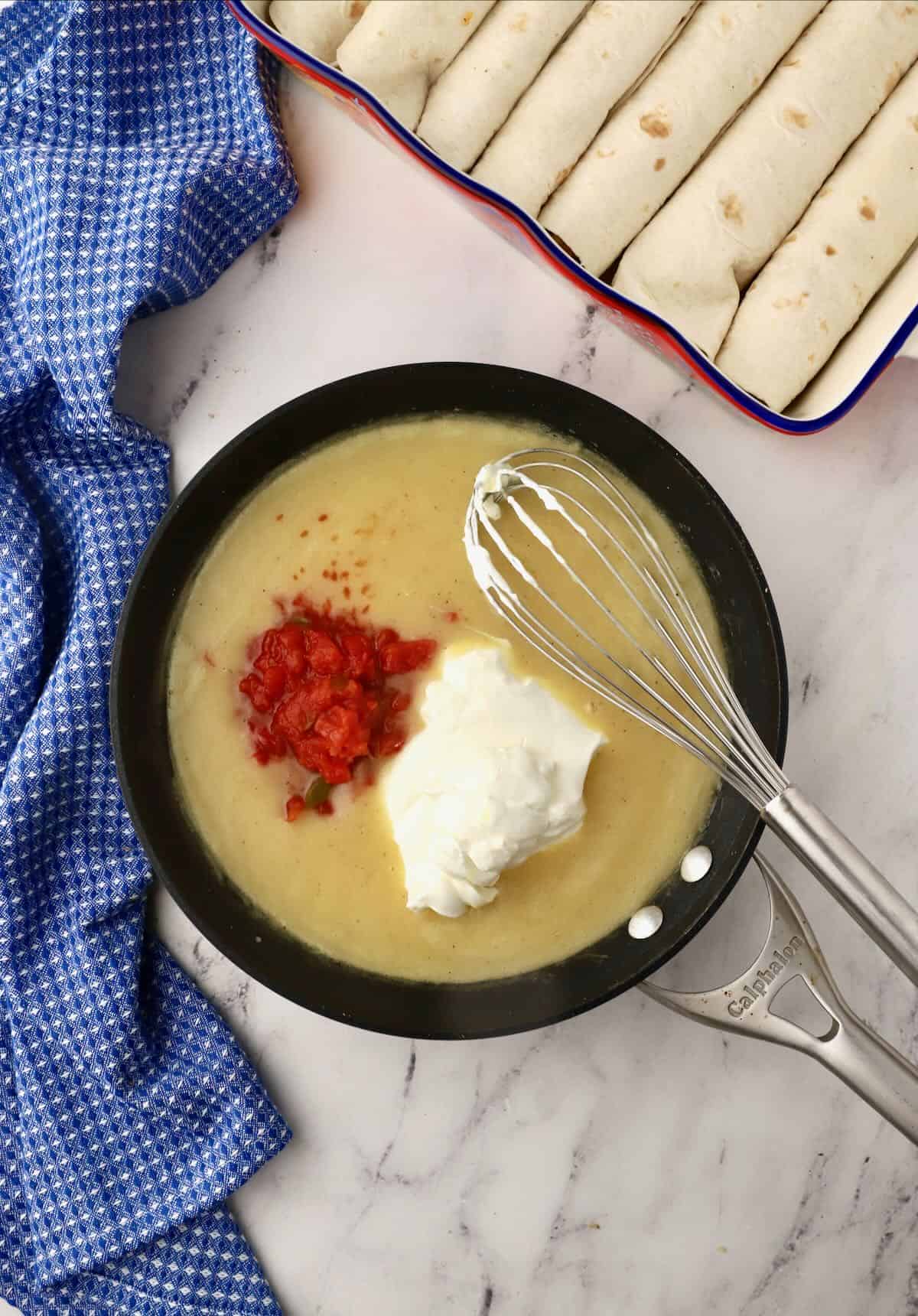 Adding sour cream and Rotel to a white sauce in a skillet. 