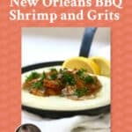 A small cast iron skillet full of grits, topped with BBQ shrimp.