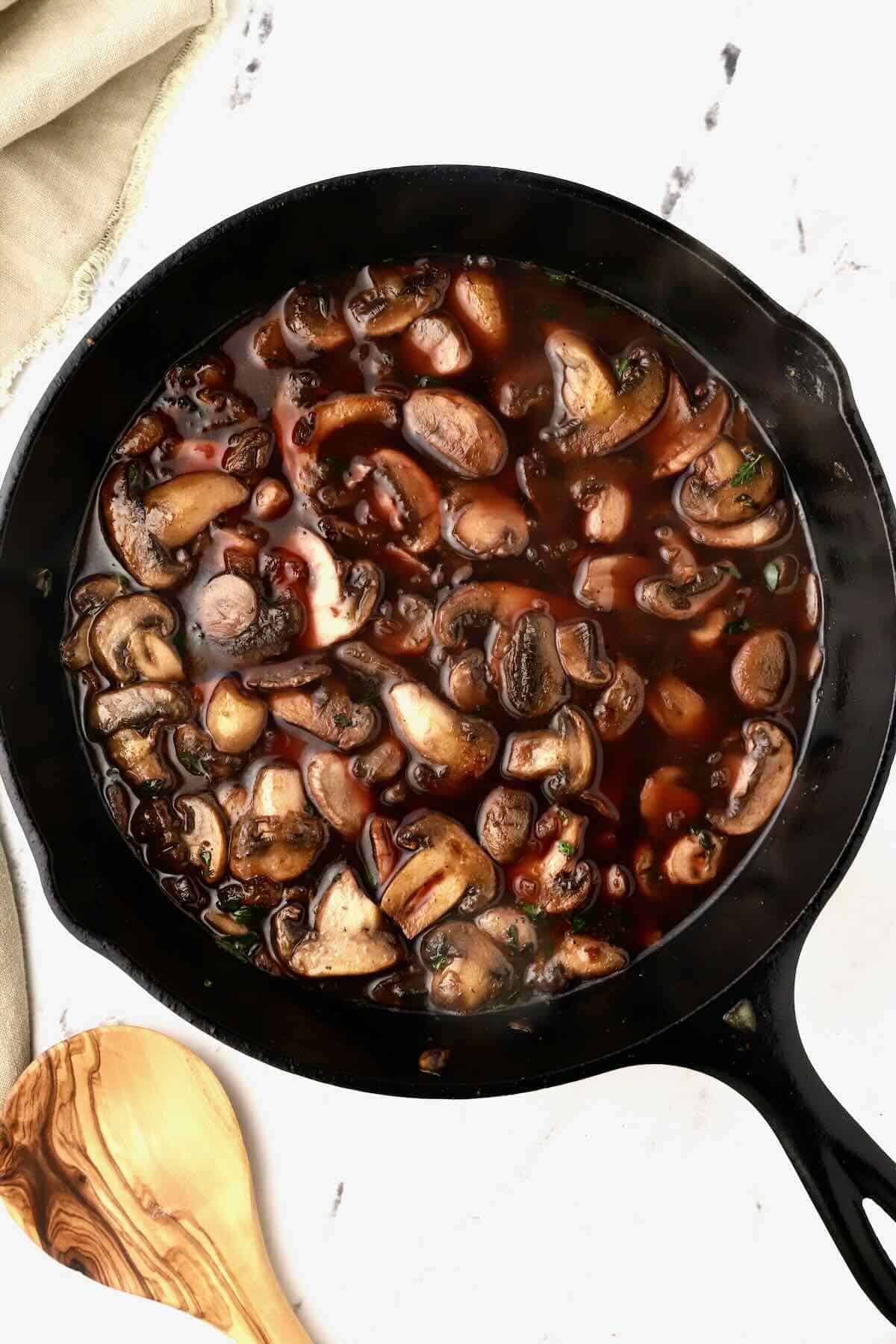 Mushrooms cooking in a red wine sauce. 
