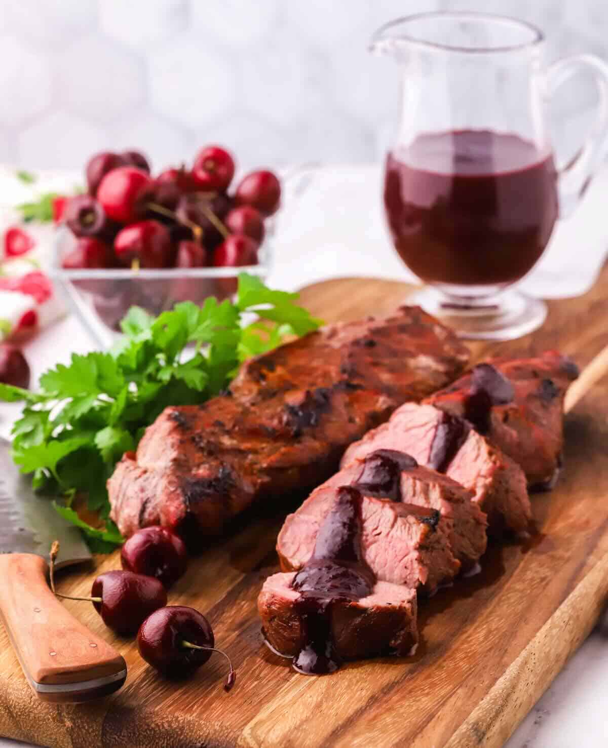 Sliced grilled pork tenderloin topped with a cherry sauce.