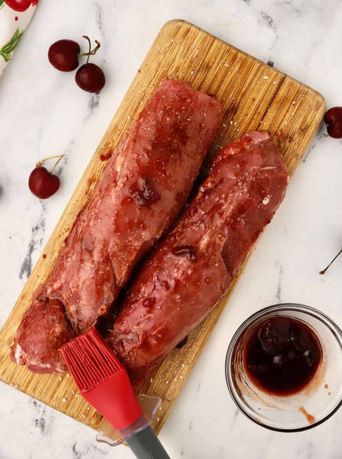 Two pork tenderloins covered with a cherry glaze. 