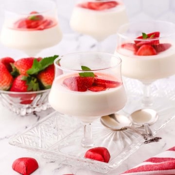 Vanilla Panna Cotta with sliced strawberries in dessert dishes.