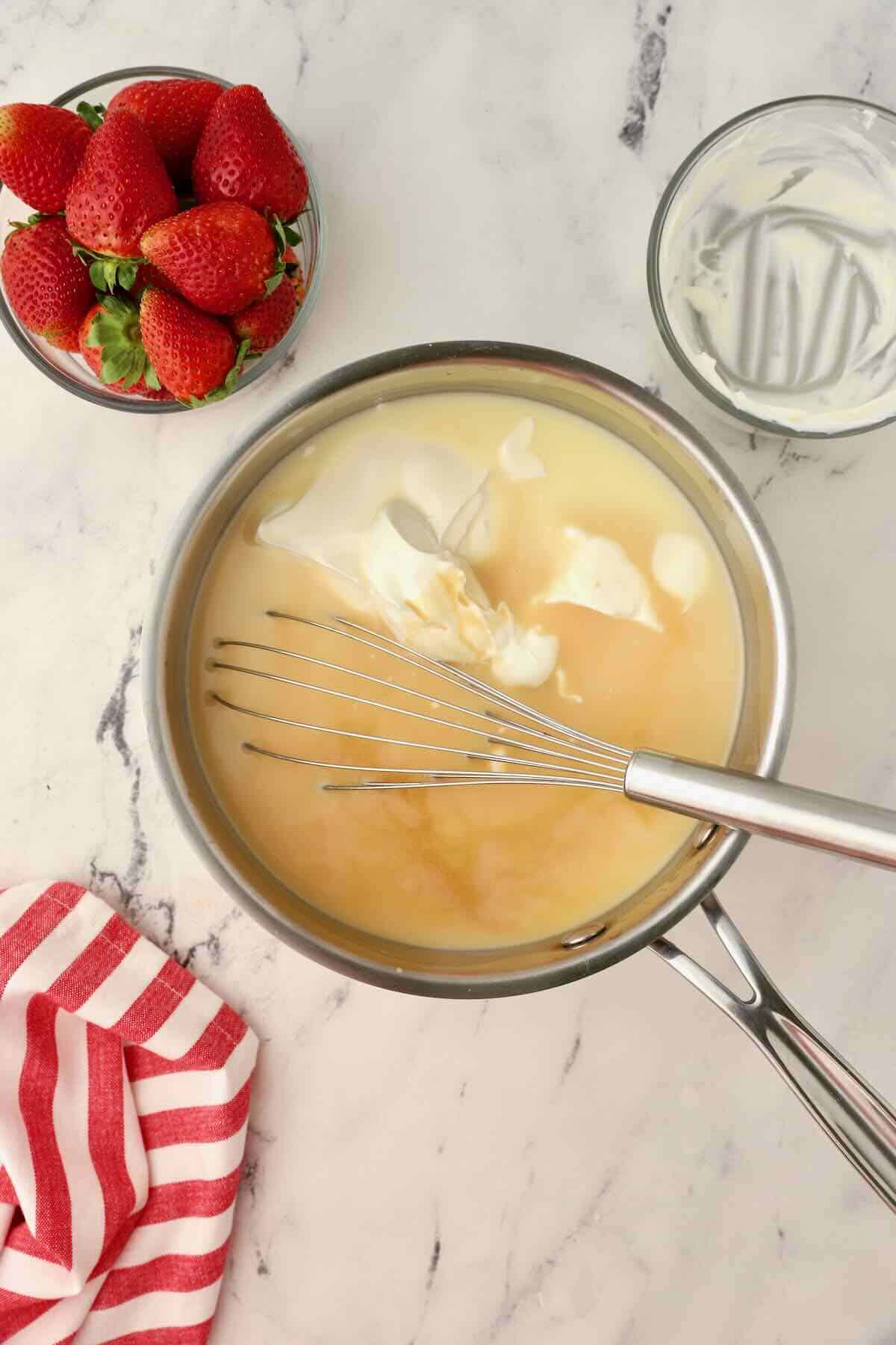 Sour cream and vanilla mixed with cream in a saucepan. 