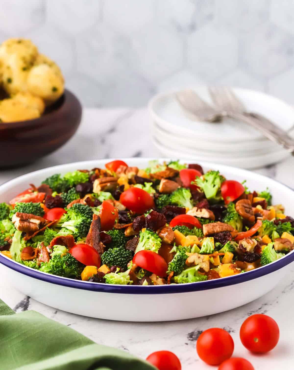 Broccoli salad in a white serving dish with a blue rim. 