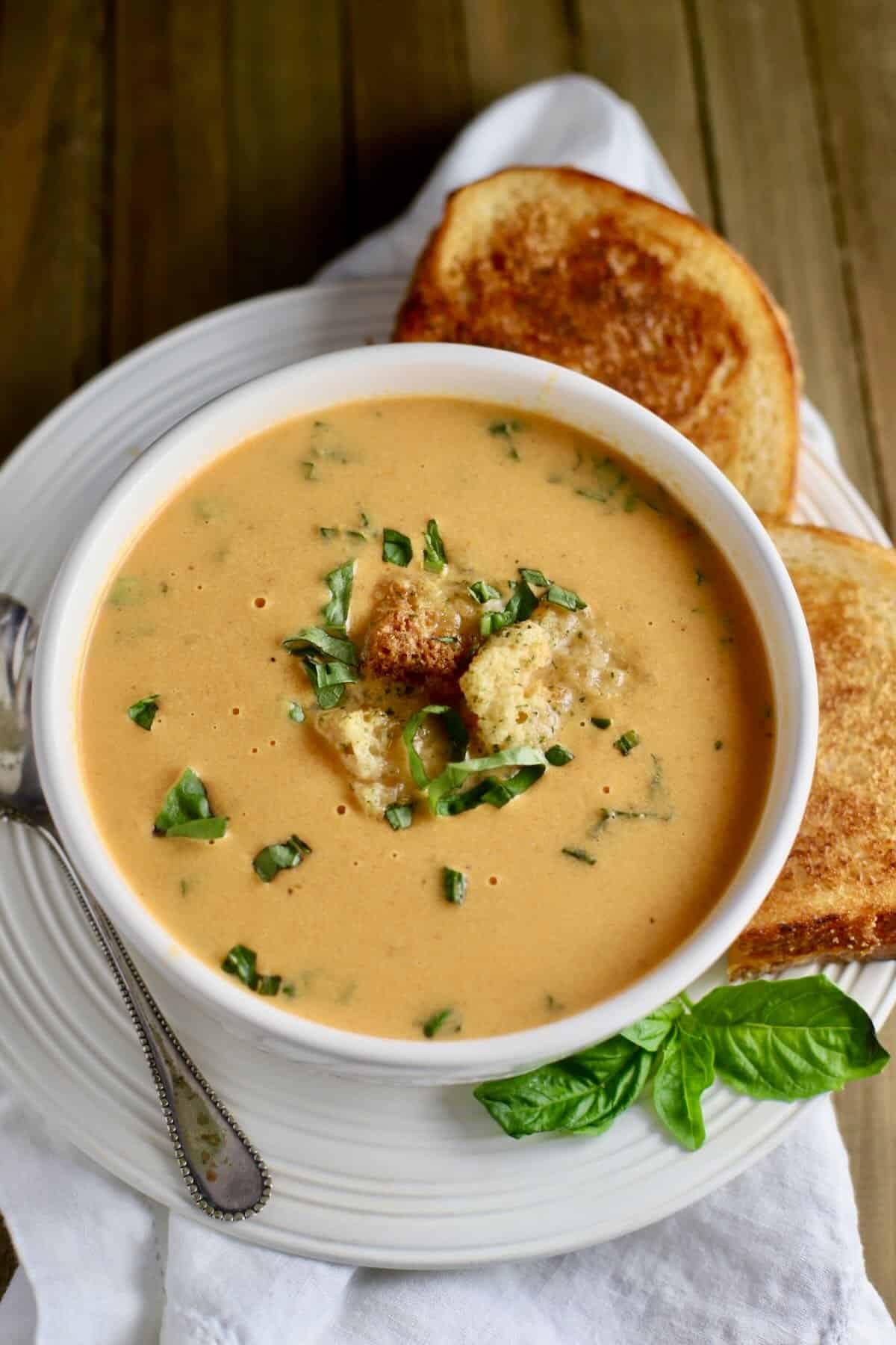 A bowl of tomato soup with a grilled cheese sandwich. 