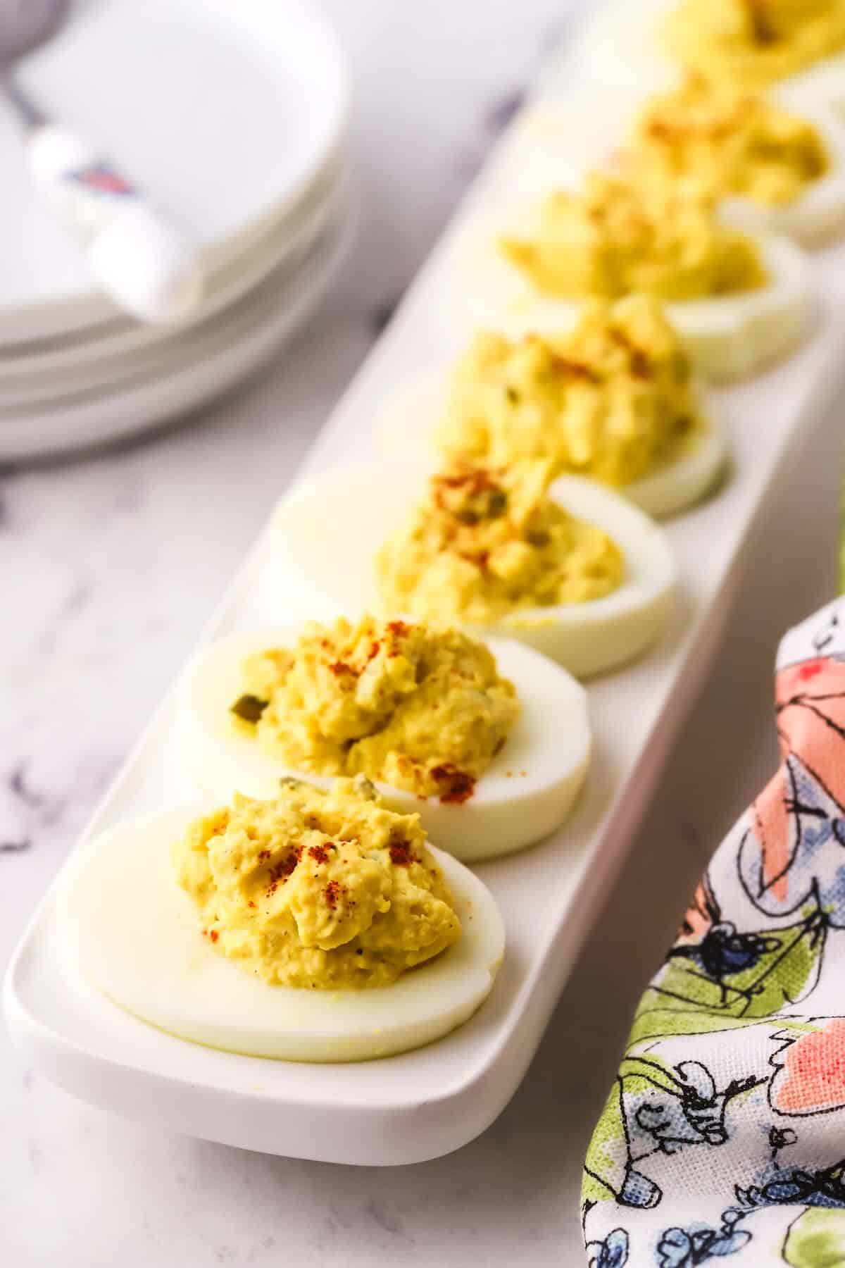 Deviled eggs on a white serving platter. 