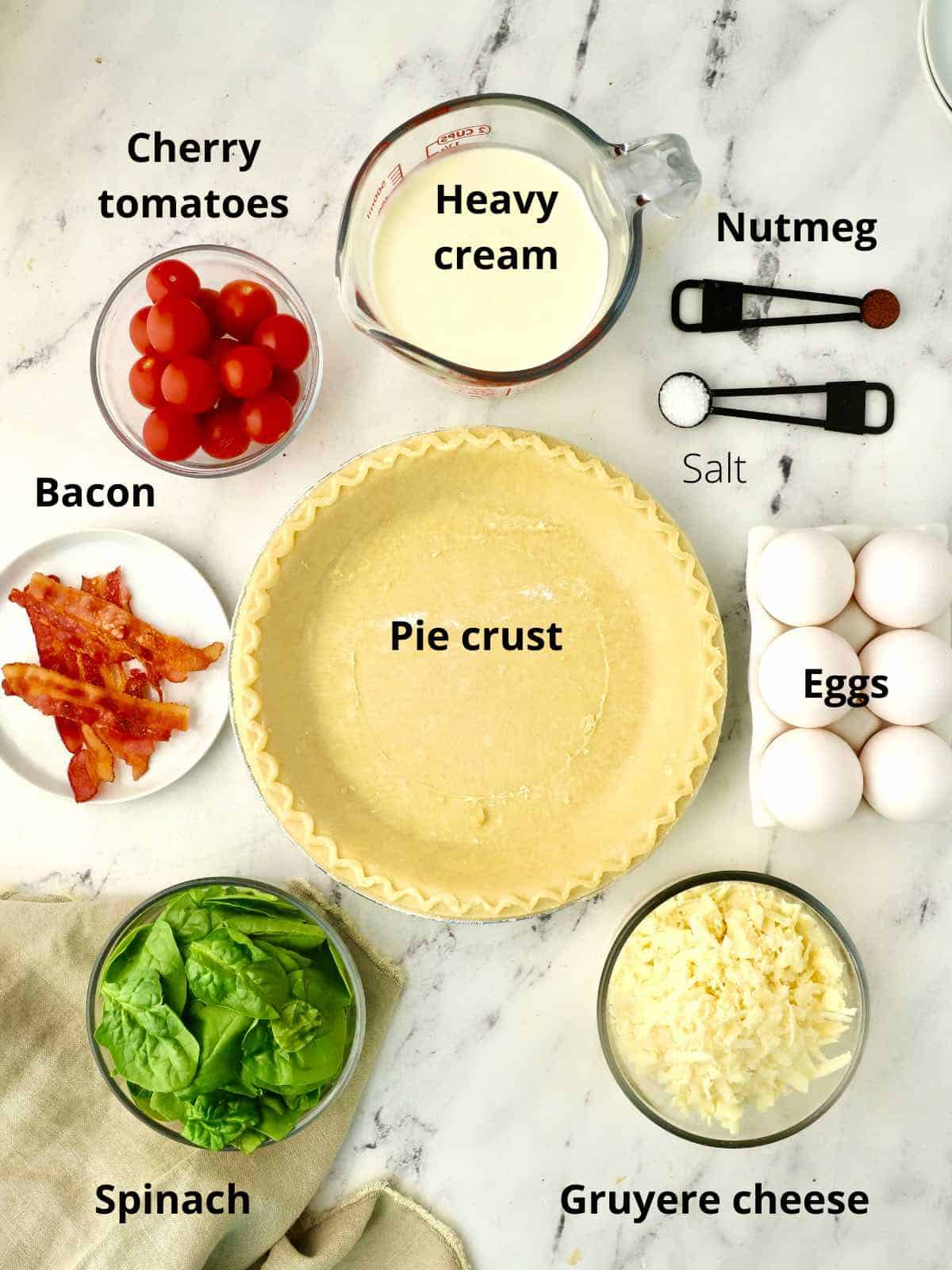 Ingredients for a quiche including a pie crust, heavy cream and eggs. 