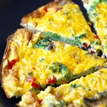 Mushroom and broccoli frittata cut into slices in a black skillet.