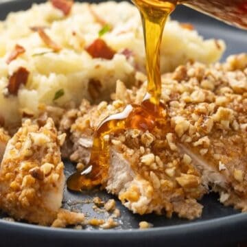 Oven Baked pecan crusted chicken breast with hot honey poured over it.