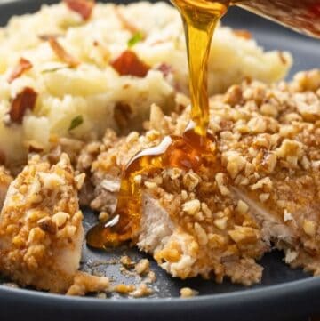 Oven Baked pecan crusted chicken breast with hot honey poured over it.