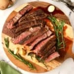 Sliced ribeye steak on a wooden cutting board.