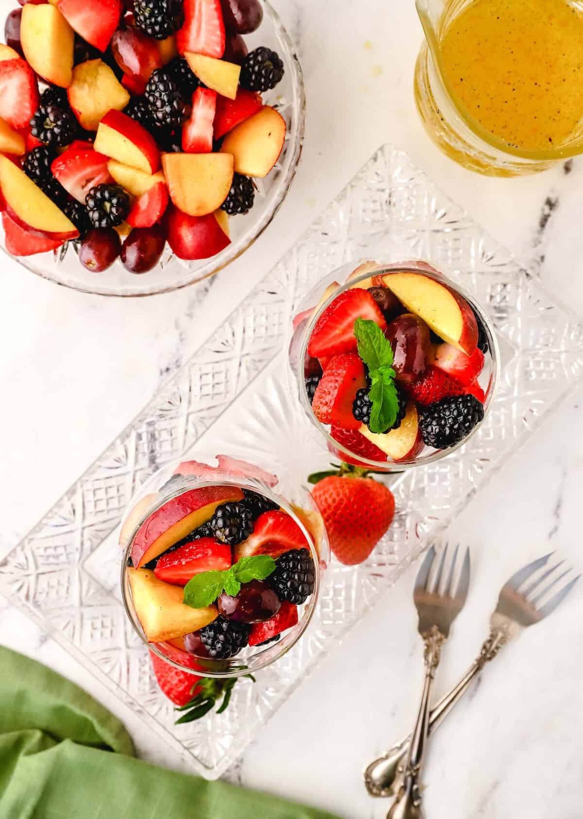 Fruit salad in two glass serving dishes.