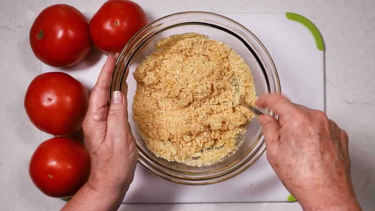 Mixing crushed Ritz crackers and melted butter in a bowl. 