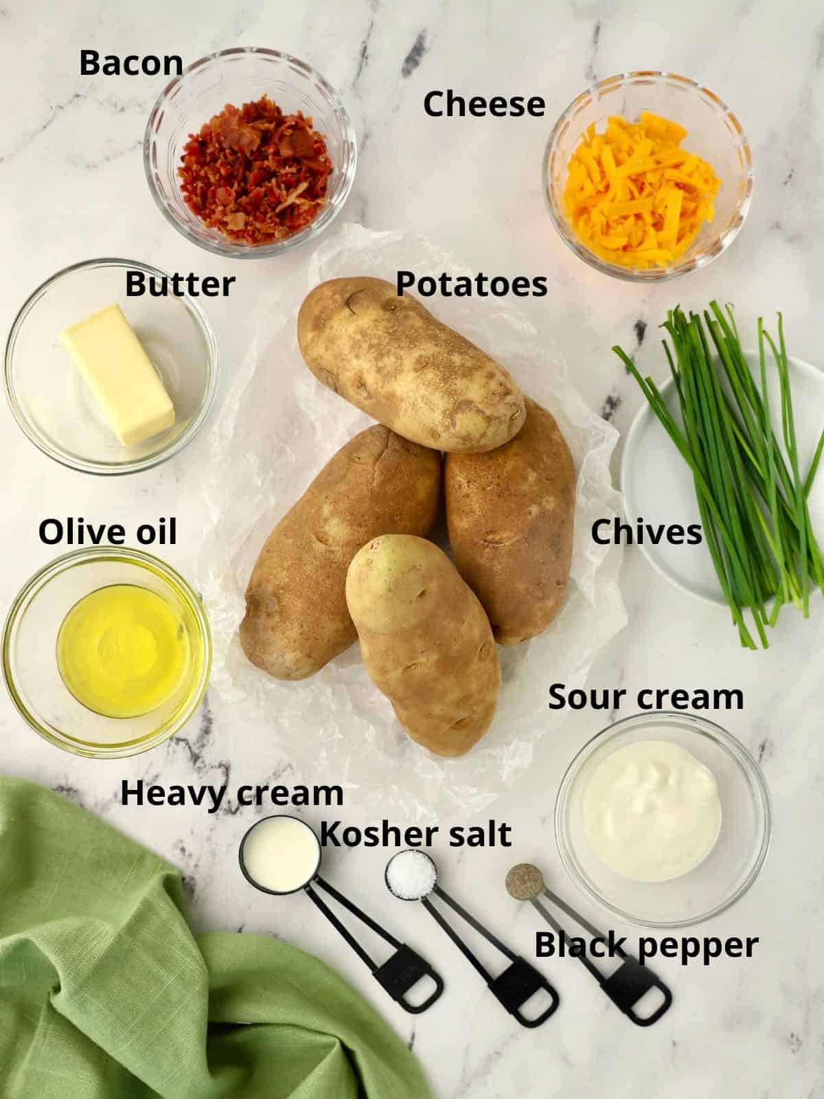 Ingredients for twice baked potatoes including sour cream, cheese and bacon. 