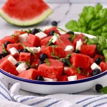 A blue and white bowl full of watermelon feta salad.