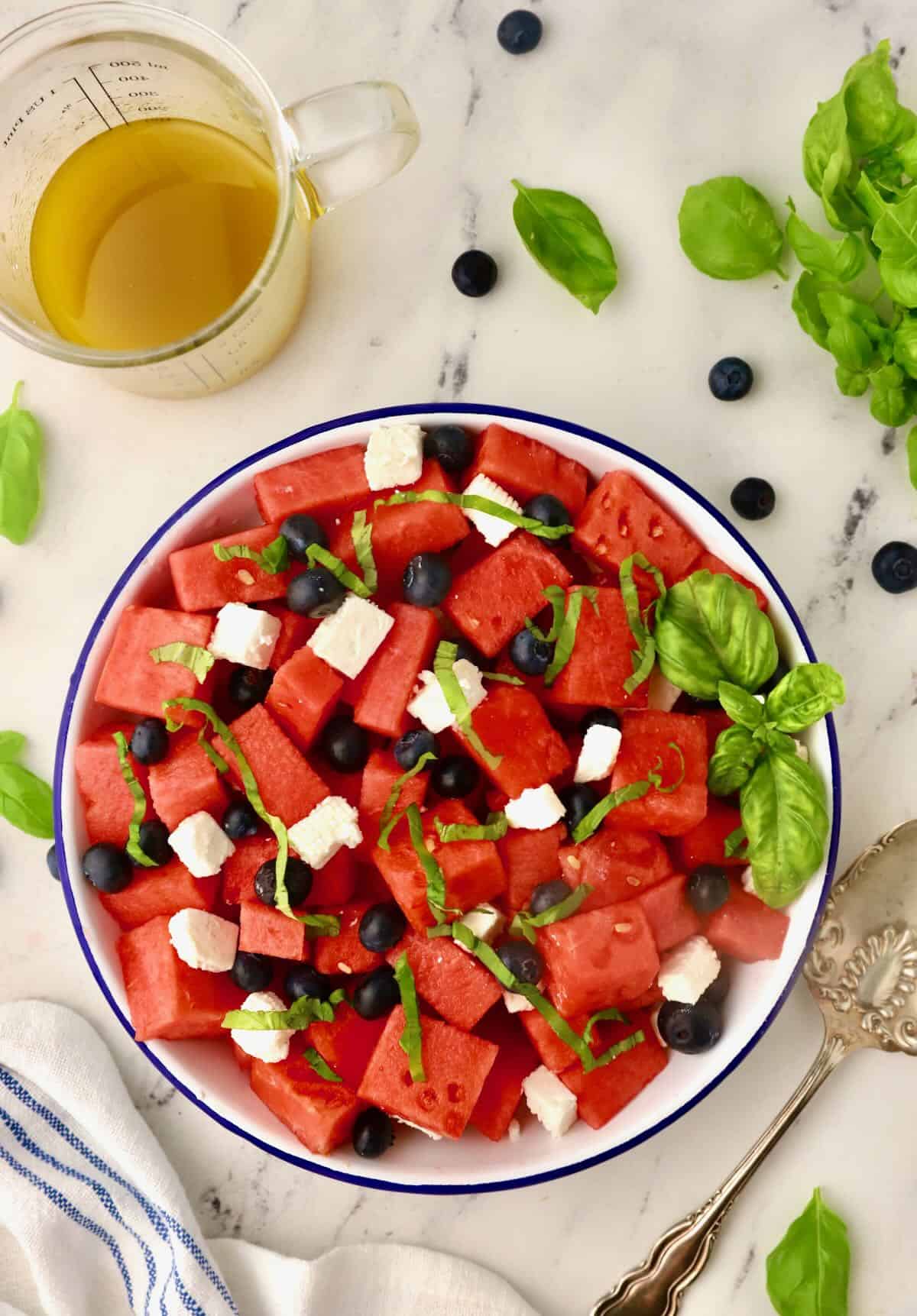 Chunks of watermelon, feta cheese and blueberries in a bowl.