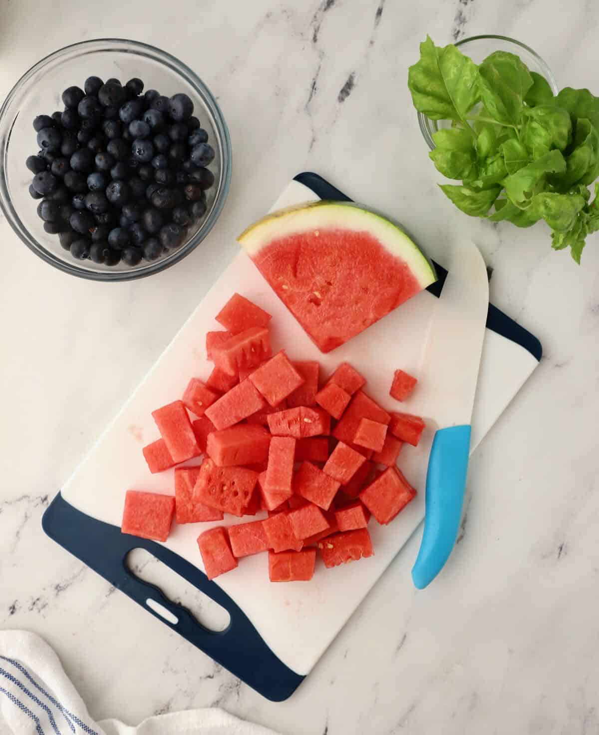 Cutting watermelon up into cubes. 