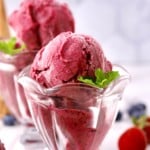 Scoops of mixed berry sherbet in glass dessert dishes.