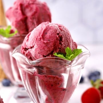 Scoops of mixed berry sherbet in glass dessert dishes.