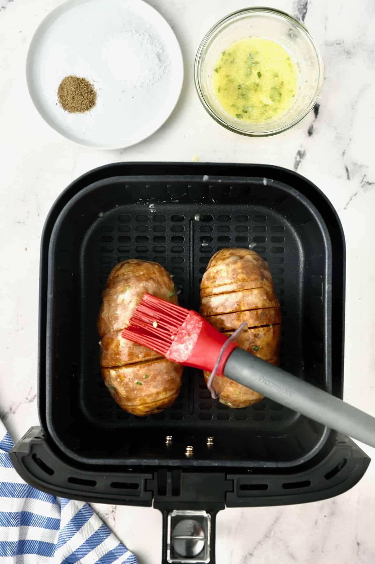 Hasselback potatoes in an air fryer basket. 