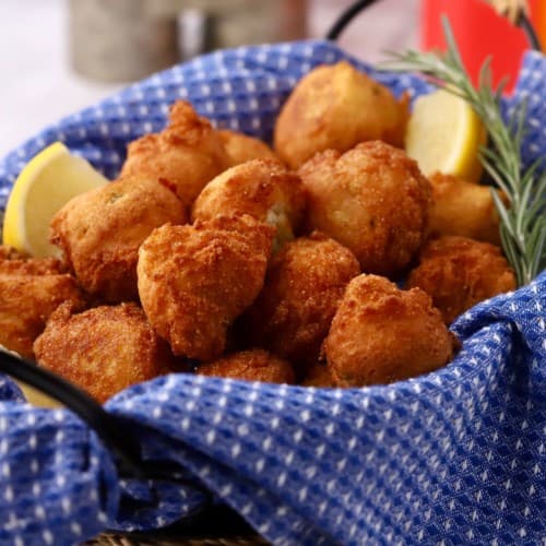 A basket full of fried hush puppies.