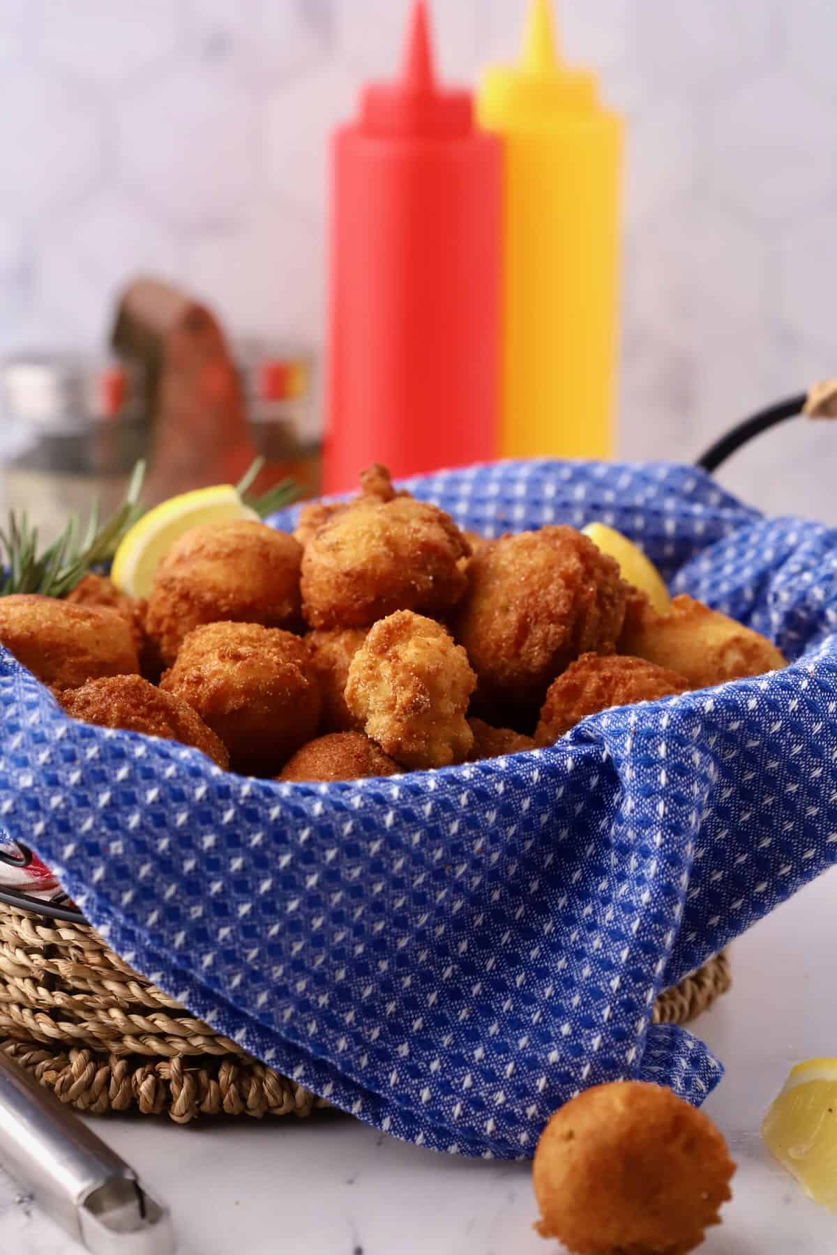 Hush puppies in a basket with a blue napkin. 