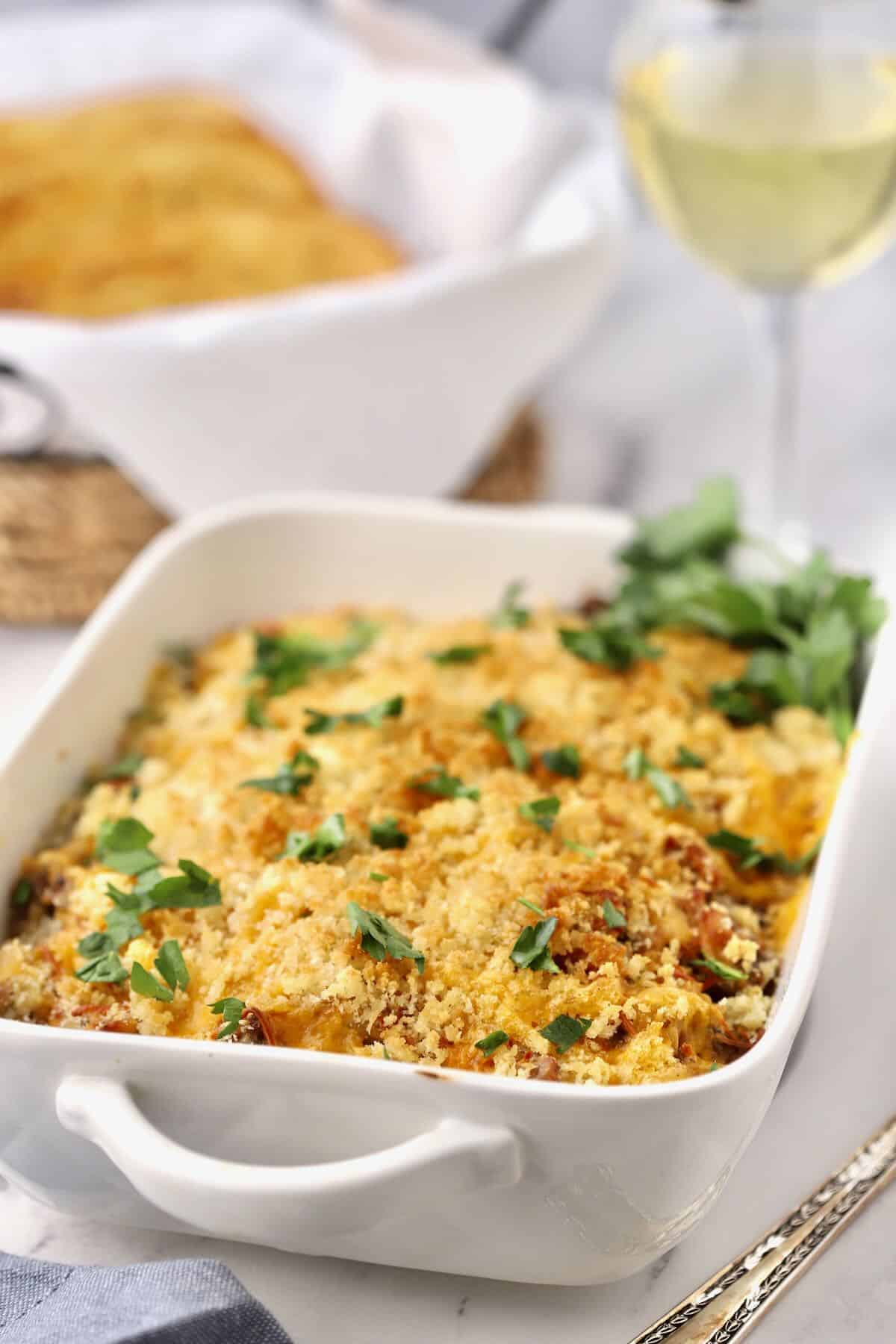 Baked chicken, sausage and wild rice casserole in a white rectangle baking dish. 